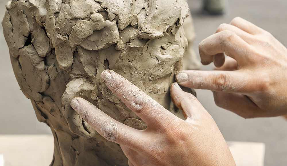 Sculptor modelling a bust using clay