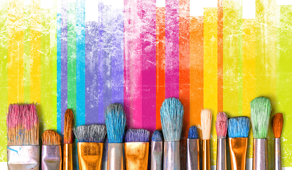A row of painbrushes and rainbow colours