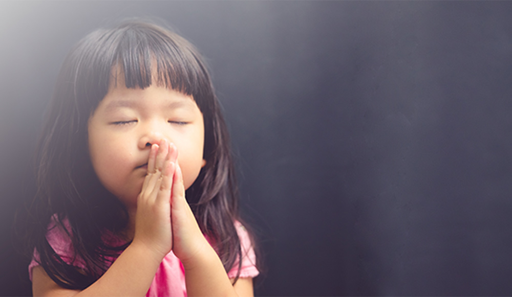 Little Asian girl praying
